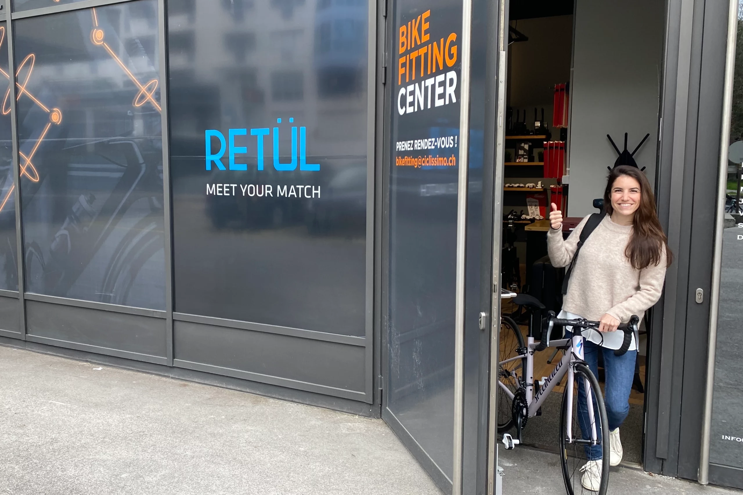 A cyclist leaving a bike fit studio with showing a thumbs up and a big smile.